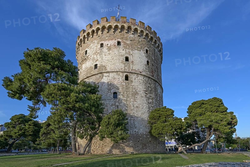 White Tower of Thessaloniki, Greece, famous landmark between pine trees and travel destination for tourists in the city, blue sky on a sunny day, copy space, selected focus, Europe
