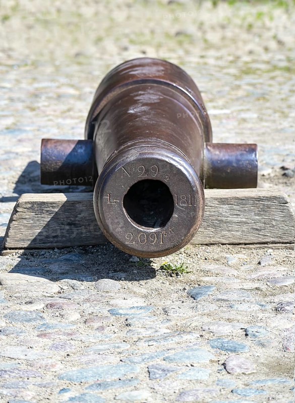 Cast iron cannon at the Holstentor or Holsten gate, historic landmark and tourist attraction in the old town of Luebeck, Germany, copy space, selected focus, Europe