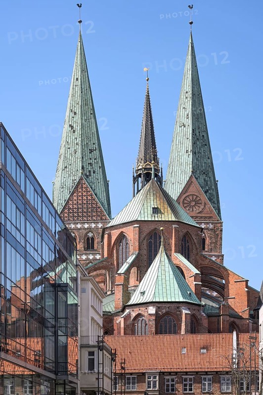 Lubeck Marienkirche or St. Mary Church, historic medieval basilica built in north German Brick Gothic with two monumental towers, seen from the west with reflections in a modern glass facade