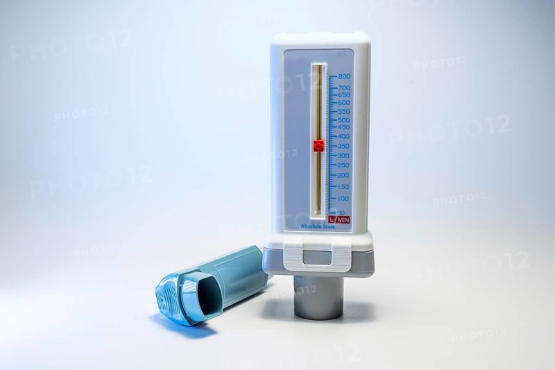 Peak flow meter and a blue inhaler, medical devices for patients with asthma allergy or COPD, light gray background with copy space, selected focus, narrow depth of field