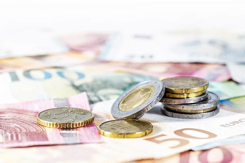 Money. Some euro coins on blurry banknotes. Economy concept for currency, business, home finance and inflation, copy space, selected focus, very narrow depth of field