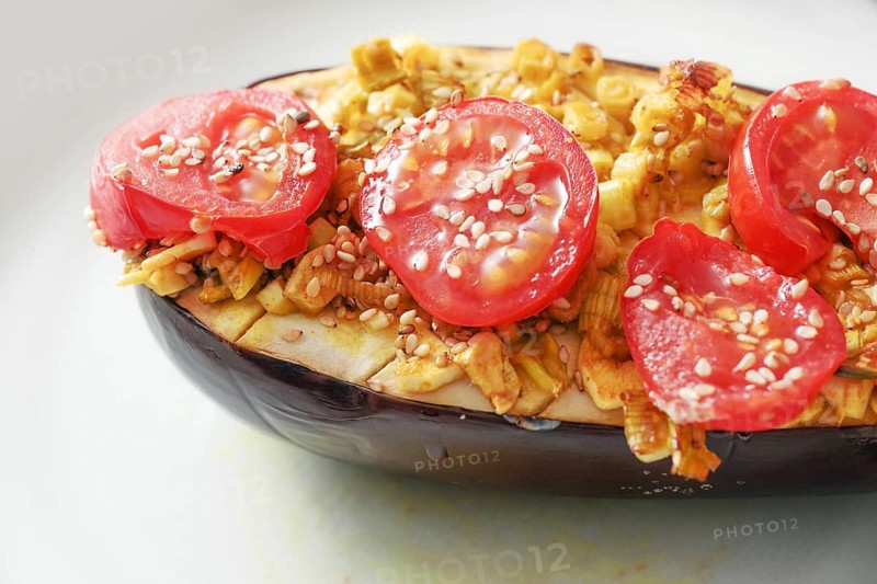 Eggplant from the oven with spaces, onions, tomatoes and sesame seed, healthy vegetarian low carb meal, selected focus, narrow depth of field
