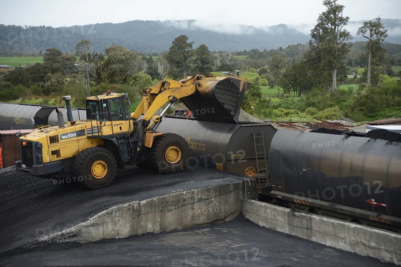 STILLWATER, NEW ZEALAND, OCTOBER 25, 2019: A payloader fills train wagons with coal at the siding at Stillwater, West Coast, New Zealand, Oceania