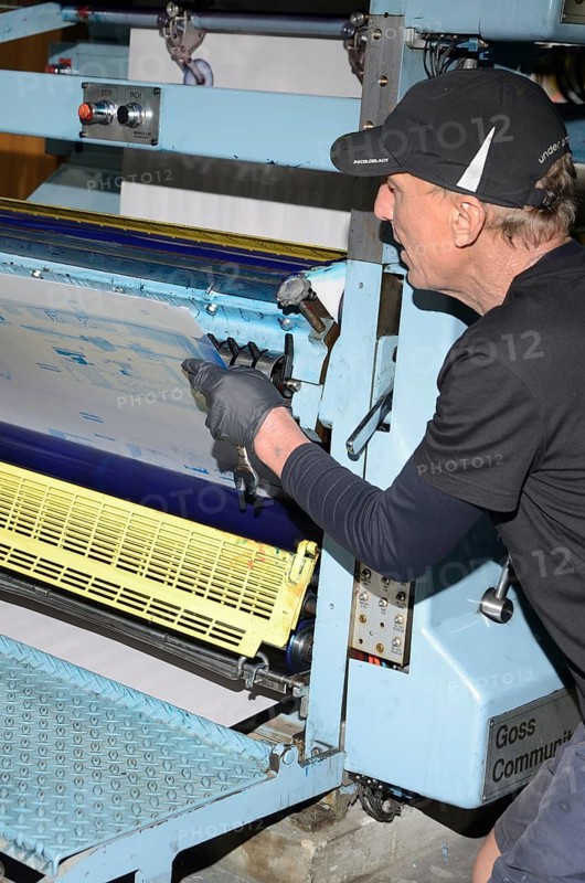 GREYMOUTH, NEW ZEALAND, MAY 22, 2015: An unidentified printer removes the plates after printing a newspaper on May 22, 2015 in Greymouth, New Zealand, Oceania