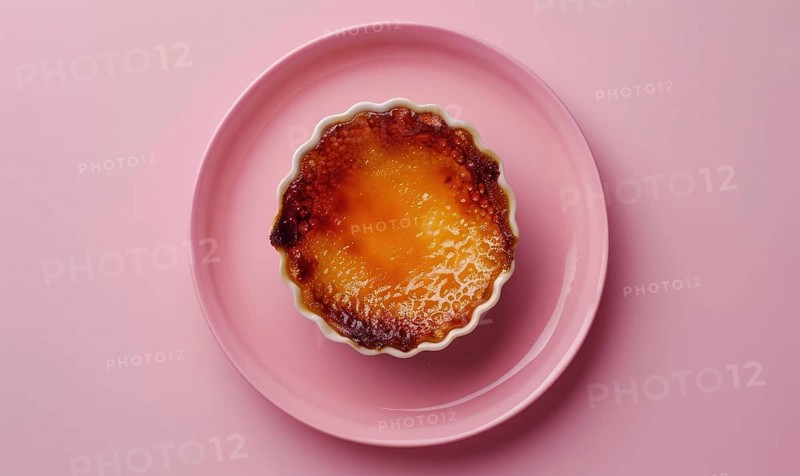 Lemon and coffee creme brulee with caramelized top on a pastel pink plate AI generated