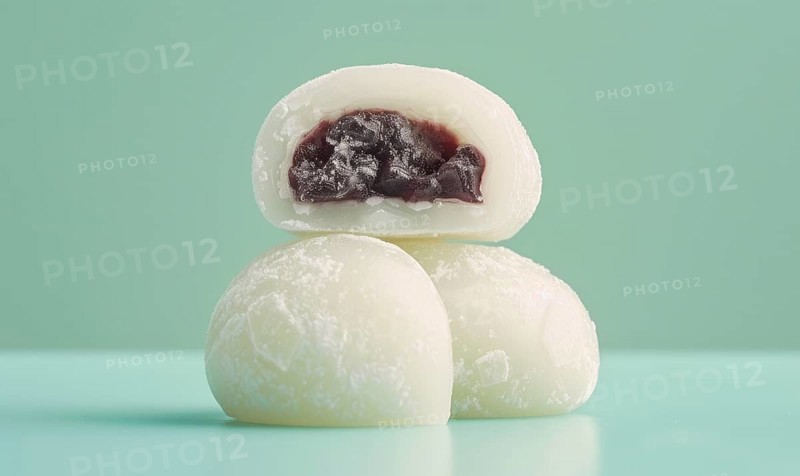 Japanese mochi with sweet red bean paste on a light green background AI generated