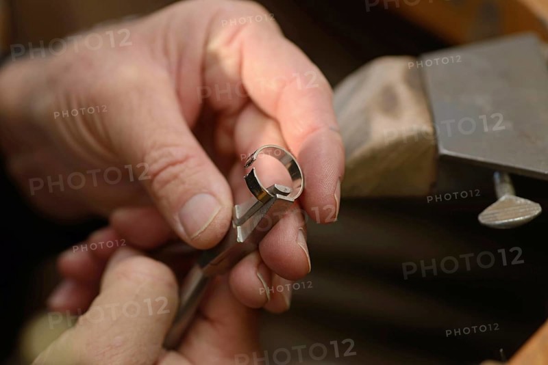 A goldsmith resizes a gold ring