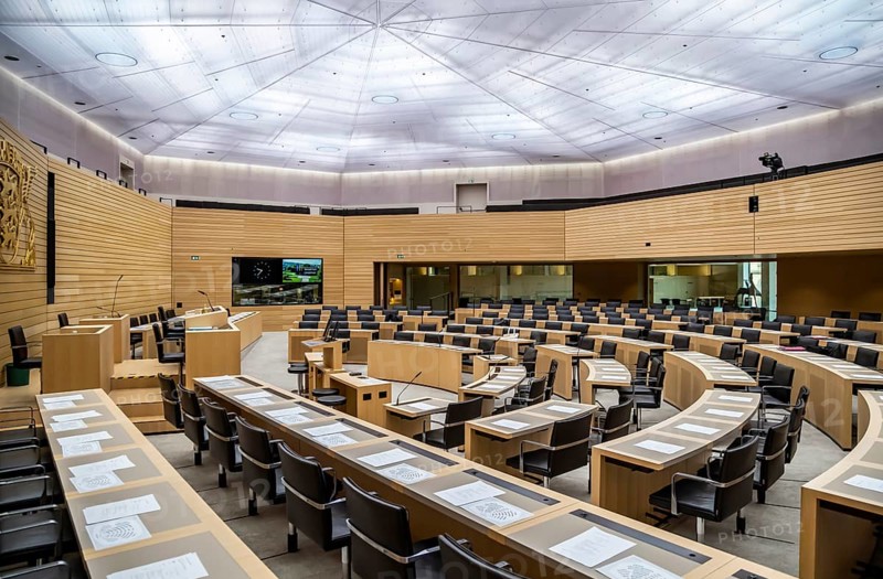 State parliament of Baden-Württemberg, assembly hall with state coat of arms. The seats of the members of parliament and ministers are empty. Stuttgart, Baden-Württemberg, Germany, Europe