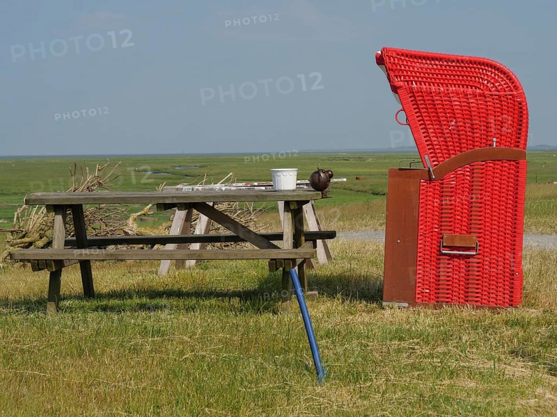 A red beach chair and a picnic table stand in a meadow under a clear sky, the surroundings are quiet and inviting, Hallig Hooge, Schleswig-Holstein, Germany, Europe