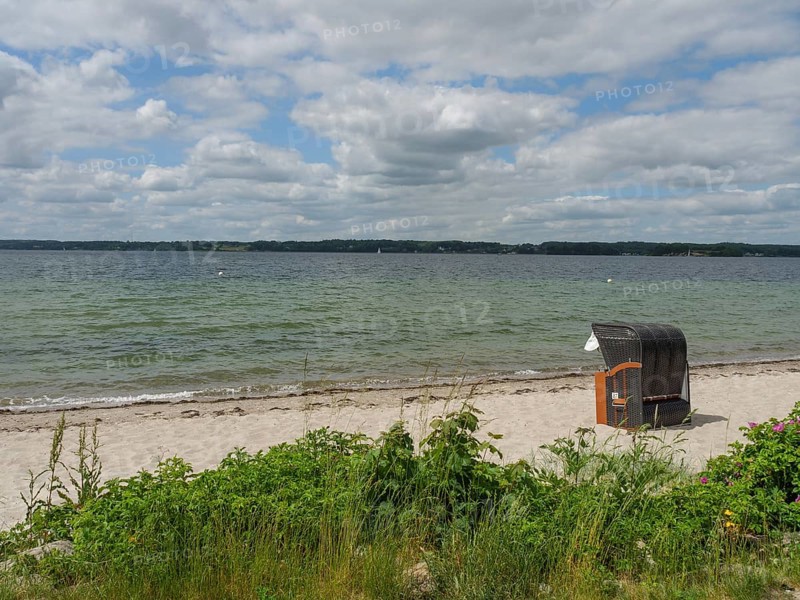 A beach with a lonely beach chair and a view of the sea under a cloudy sky, Glücksburg, Schleswig-Holstein, Germany, Europe