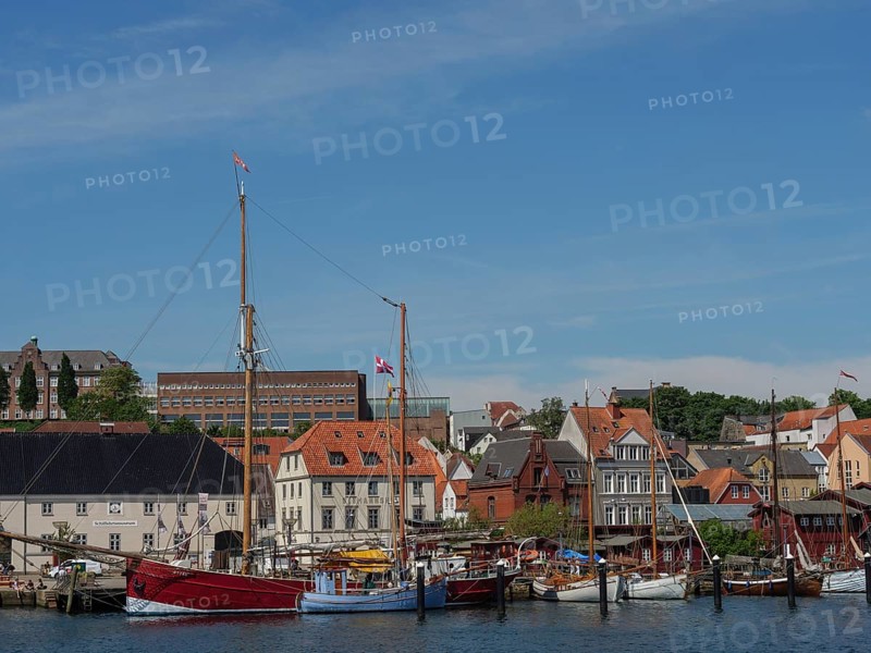 Idyllic harbour with sailing ships and charming old buildings on the shore under a blue sky, Flensburg, Schleswig-Holstein, Germany, Europe