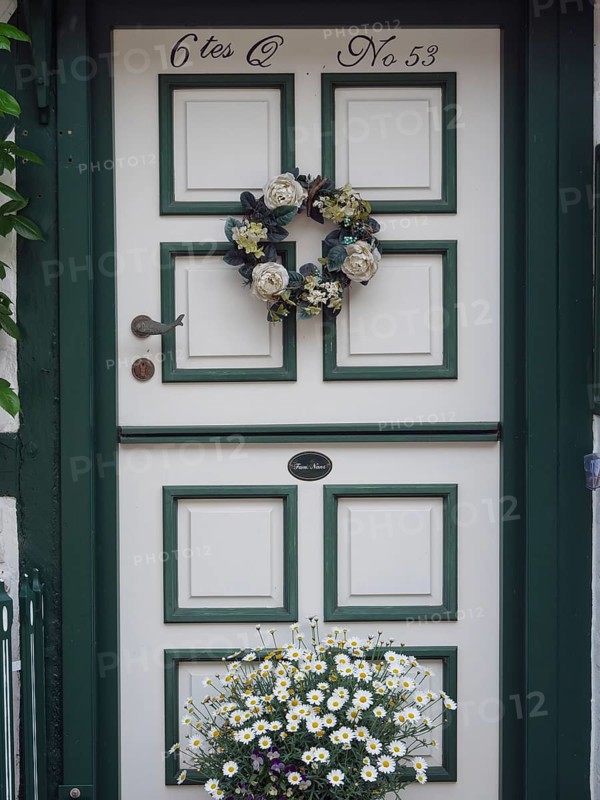 A beautifully decorated door with a wreath of flowers and a flower box underneath, Schleswig, Schleswig-Holstein, Germany, Europe