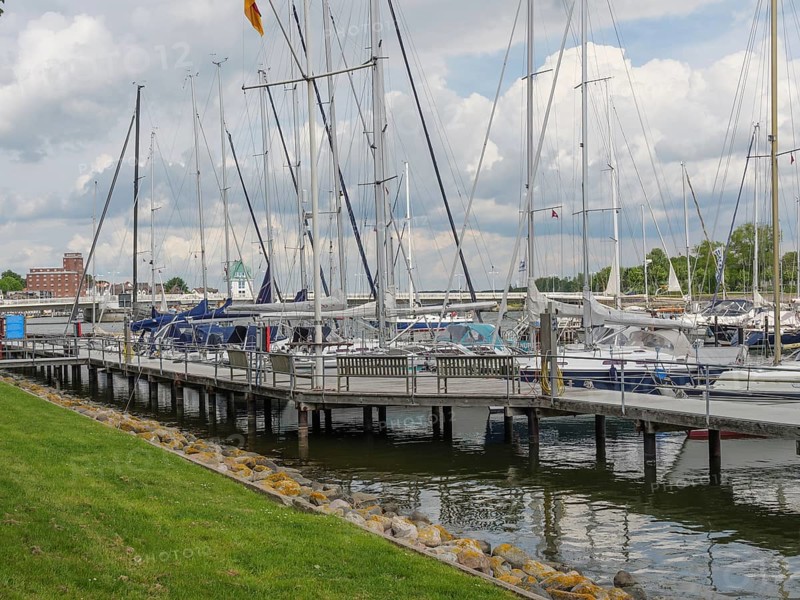 Sailboats dock at the marina in a partly cloudy sky with manicured lawn, Kappeln, Schleswig-Holstein, Germany, Europe