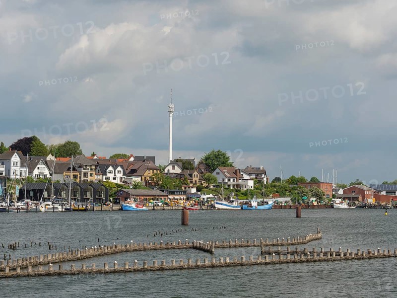 A city view with a television tower, buildings and boats on the waterfront under a partly cloudy sky, Kappeln, Schleswig-Holstein, Germany, Europe