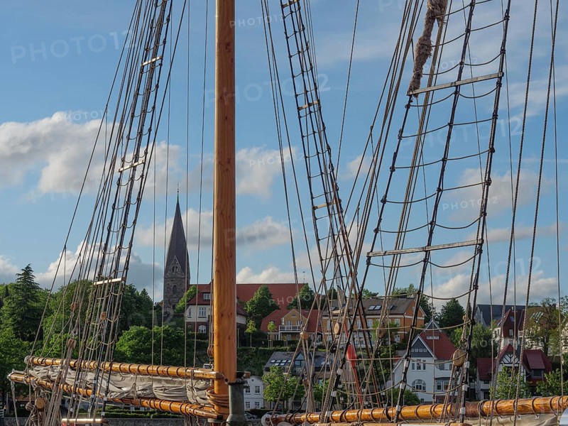 Detail of a sailing mast with a view of a church and houses in the background, Eckernförde, Schleswig-Holstein, Germany, Europe