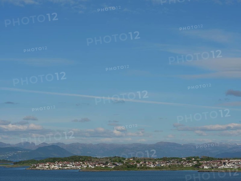 Expansive coastal landscape with a view of the sea and mountains under a slightly cloudy sky, Stavanger, Norway, Europe