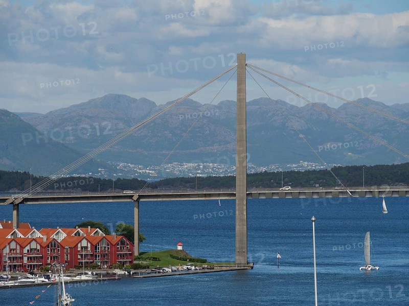 Bridge over the sea with mountains and houses with red roofs in the foreground, Stavanger, Norway, Europe