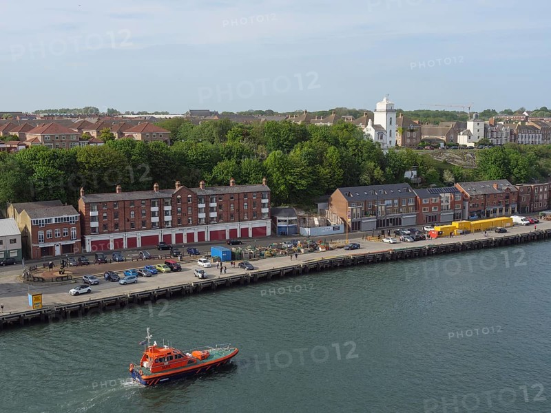 A coastal town with buildings and a boat in the harbour, Newcastle, England, Great Britain