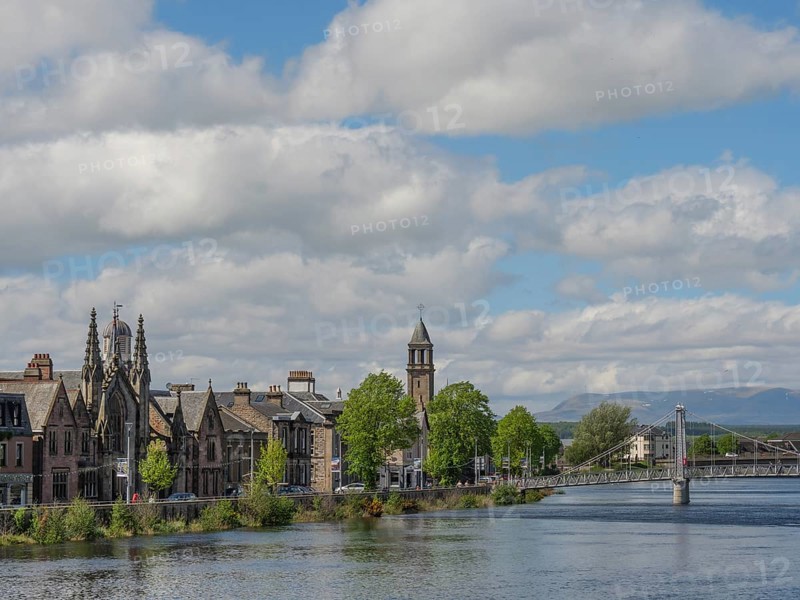 Historic buildings and a bridge over the river, surrounded by trees with mountains in the background, inverness, Scotland, United Kingdom, Europe