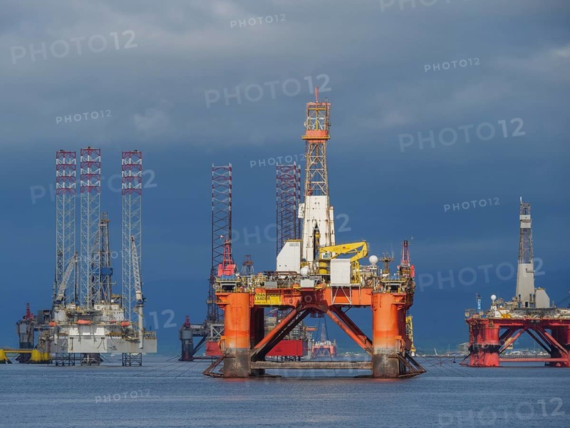 Several drilling platforms stand in the calm sea under an overcast sky, inverness, Scotland, United Kingdom, Europe