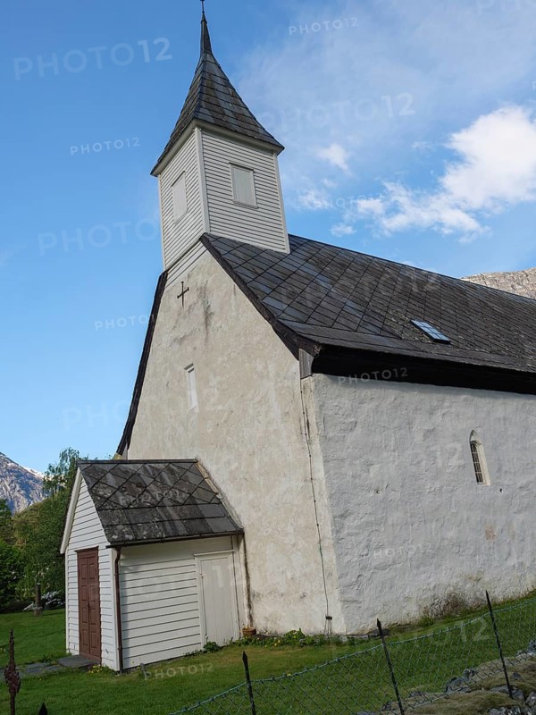 White church with tower under a clear sky, surrounded by green nature and mountains, Eidfjord NOR 3