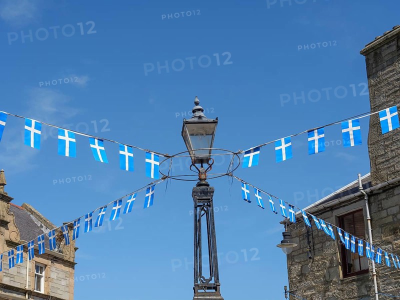 Lamp with hanging Scottish flags in front of a historic building and blue sky, Lerwick, Shetlands, Scotland, United Kingdom, Europe