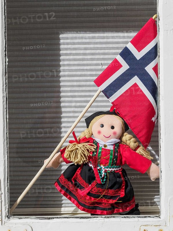 A doll in traditional traditional costume holds a Norwegian flag and stands in a window, Stavanger, Norway, Europe