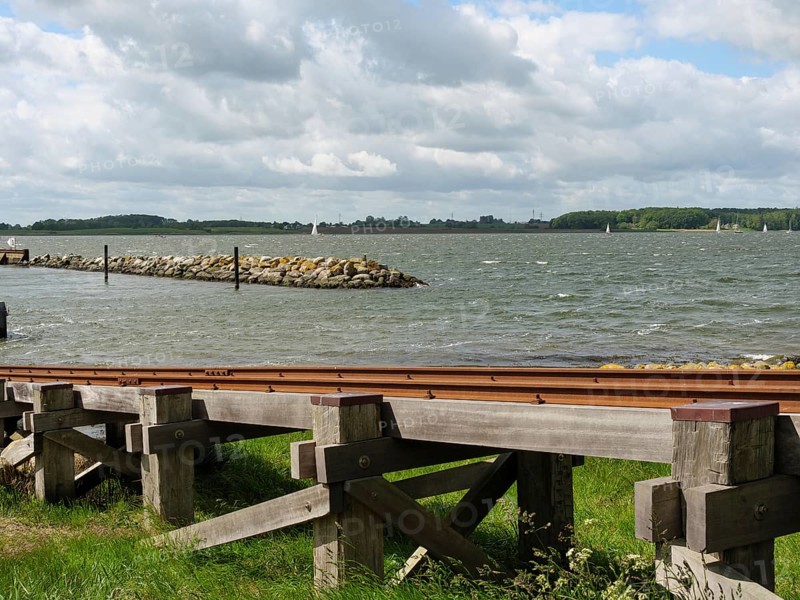 View of a wooden jetty on the lake under a partly cloudy sky, Maasholm, Schleswig-Holstein, Germany, Europe