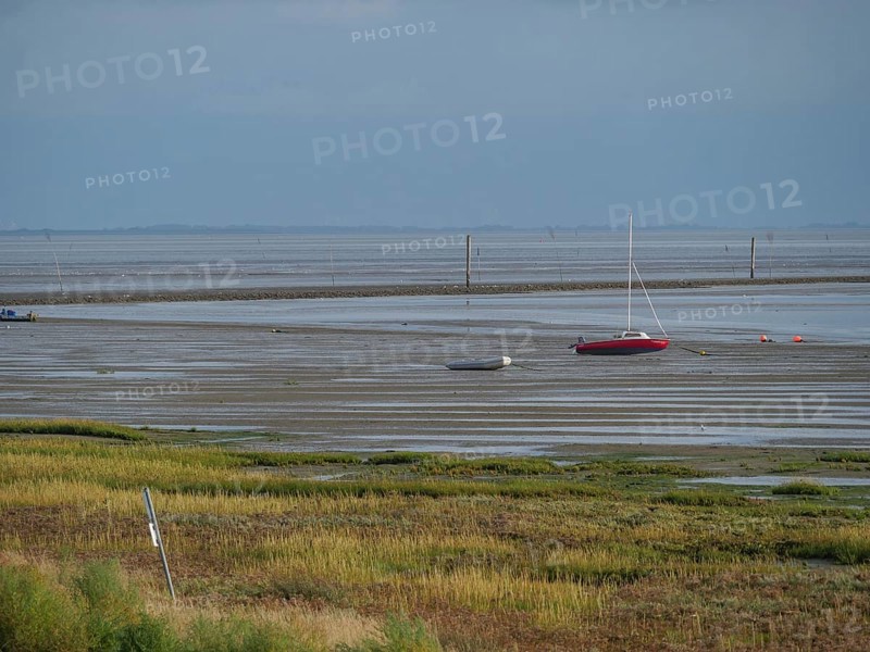 Wide mudflats with boats in the shallow water and a calm, peaceful feeling, juist, east frisia, germany