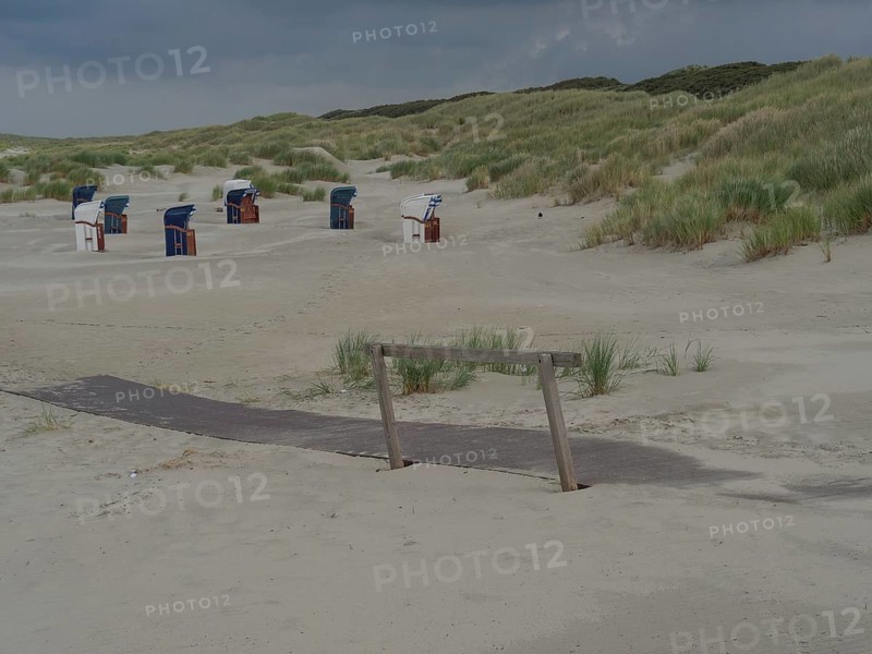 View of a beach with dunes and beach chairs in the background, wooden path embedded in the sand, cloudy sky, Juist, East Frisia, Germany, Europe