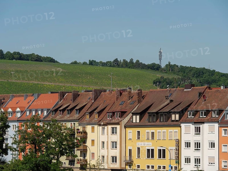Row of colourful houses in front of green vineyards and a television tower on the horizon, Würzburg, Bavaria, Germany, Europe