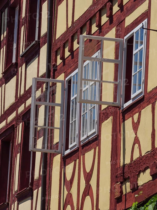 Close-up of a half-timbered house with open windows and visible details in the sunlight, Meersburg, Germany, Europe