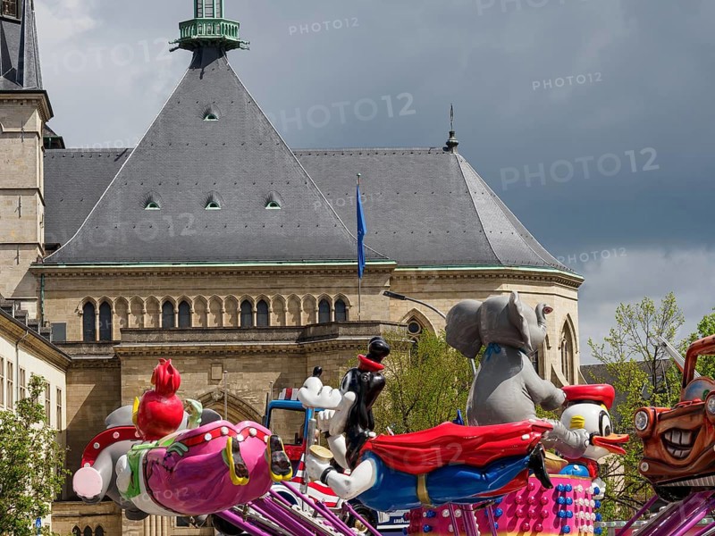 Colourful funfair with figures and carousel in front of a historic building, Luxembourg City, Luxembourg, Europe