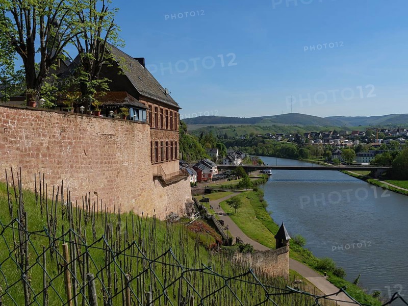 View of a river flanked by an old wall and buildings that blend into the landscape, Saarburg, Germany, Europe