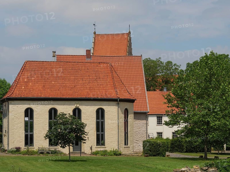 A small chapel with red roof tiles and large windows, surrounded by meadows and a tree, under a cloudy sky, Steinfurt, North Rhine-Westphalia, Germany, Europe
