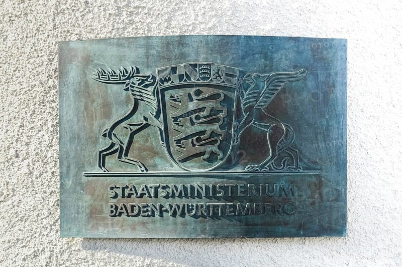 Information plaque on the wall of Villa Reitzenstein, coat of arms, State Ministry of Baden-Württemberg, script, letters, the large state coat of arms, sovereign sign, design by graphic artist Fritz Meinhard, three striding lions, the shield is held by a stag and a mythical creature, the griffin, official residence of the State Ministry of Baden-Württemberg and the incumbent Minister President, Stuttgart, Baden-Württemberg, Germany, Europe