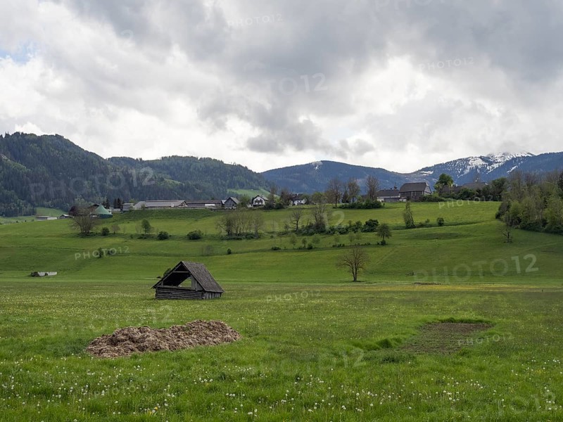 Thunderclouds over a hay barn in a meadow, mountain peak in the background, near Irdning, Ennstal, Styria