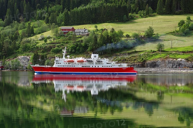 A cruise ship is reflected on a calm fjord in front of a green landscape, Nordfjord, Loen, Norway, Europe