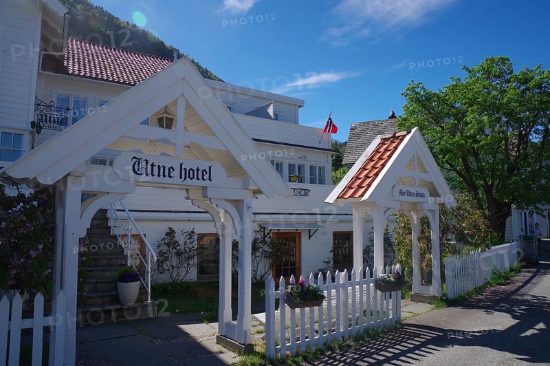 Historic wooden hotel with white facades, red roofs, flowers and blue sky, Edvard Grieg, Utne, Hardanger, Hardangerfjord, Norway, Europe