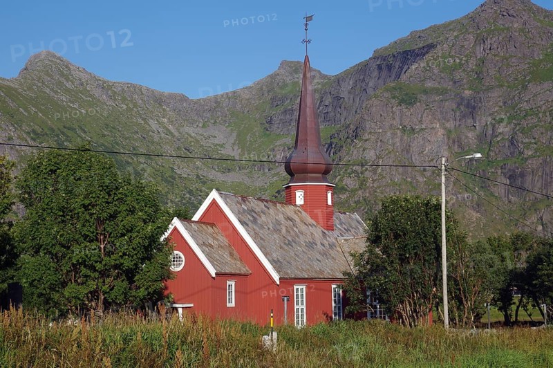 Red church with tower surrounded by trees and mountains under a clear blue sky, onion dome, Flakstad, Lofoten, Nordland, Norway, Europe