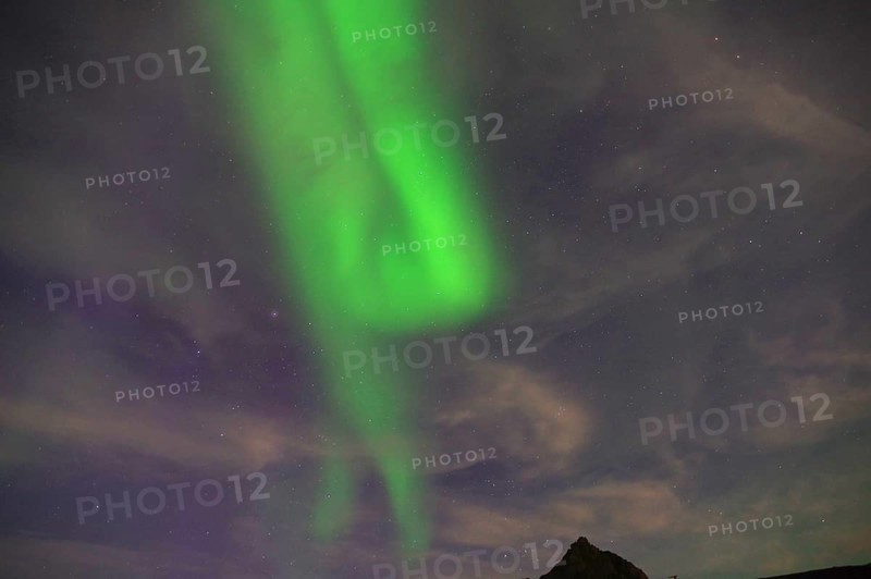 Green Northern Lights stretching across a mountain landscape against a starry night sky, Nyksund, Vesteralen, Nordland, Norway, Europe
