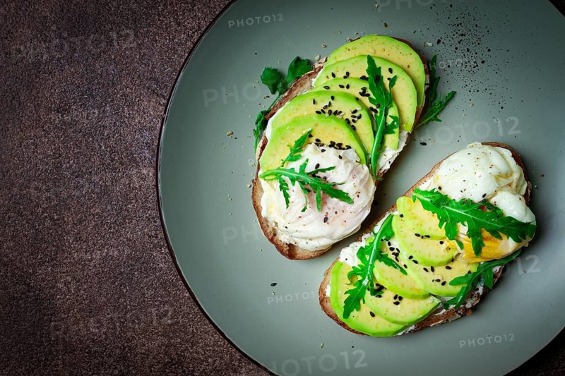 Sandwich with cream cheese, sliced avocado and boiled egg, arugula, on grainy bread, homemade, breakfast, no people