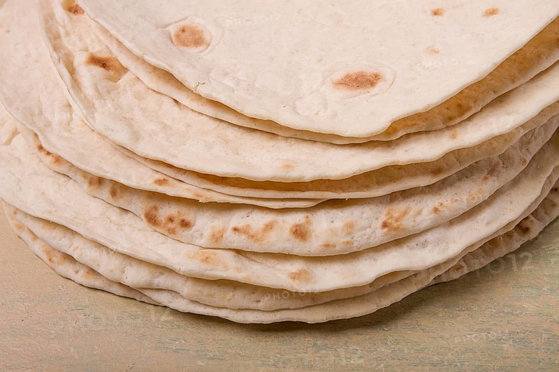A stack of Mexican tortillas, on a gray table, top view, close-up, no people