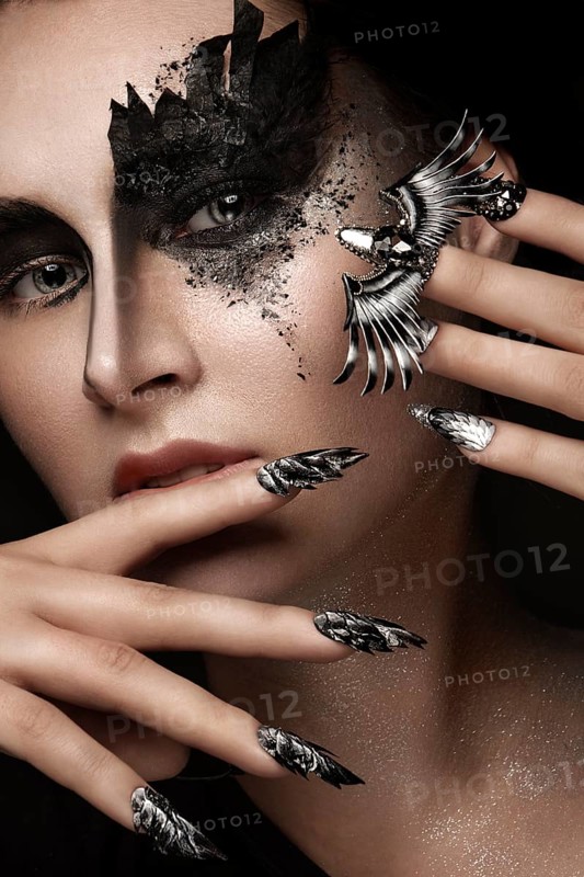 Portrait of a beautiful woman with art make-up, creative long nails. Design manicure. Beauty face. Picture taken in the studio