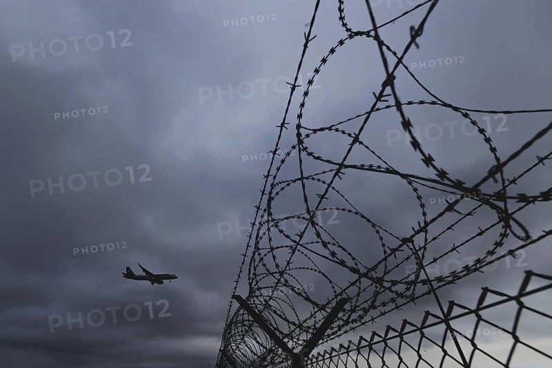 An aircraft looms over a barbed wire fence, taken at Berlin Brandenburg Airport 'Willy Brandt'Äô (BER) in Schönefeld, 08/08/2024