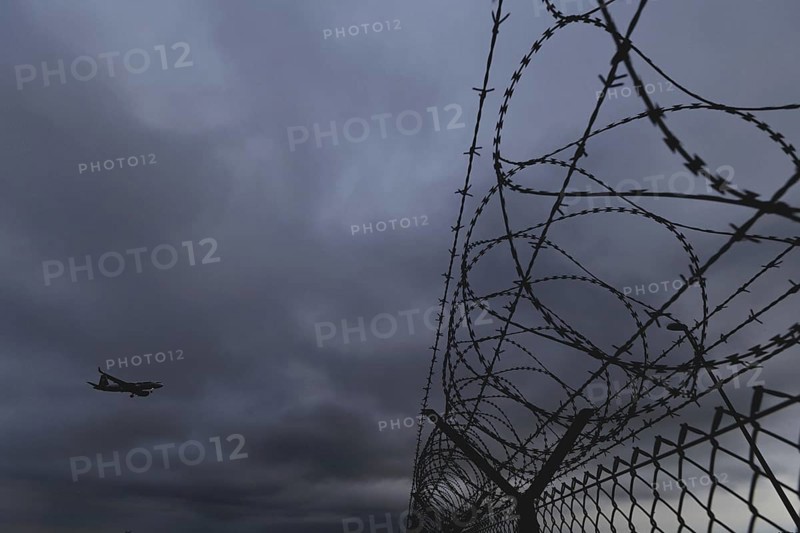 An aircraft looms over a barbed wire fence, taken at Berlin Brandenburg Airport 'Willy Brandt'Äô (BER) in Schönefeld, 08/08/2024