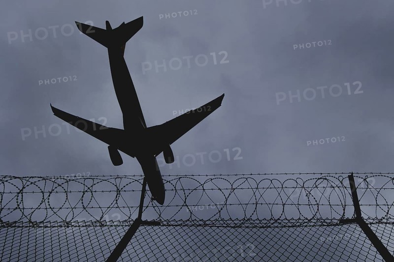 An aircraft looms over a barbed wire fence, taken at Berlin Brandenburg Airport 'Willy Brandt'Äô (BER) in Schönefeld, 08/08/2024