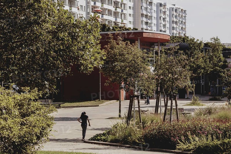 A boy with a football stands out in a green area between blocks of flats in Marzahn, taken in Berlin, 07/08/2024
