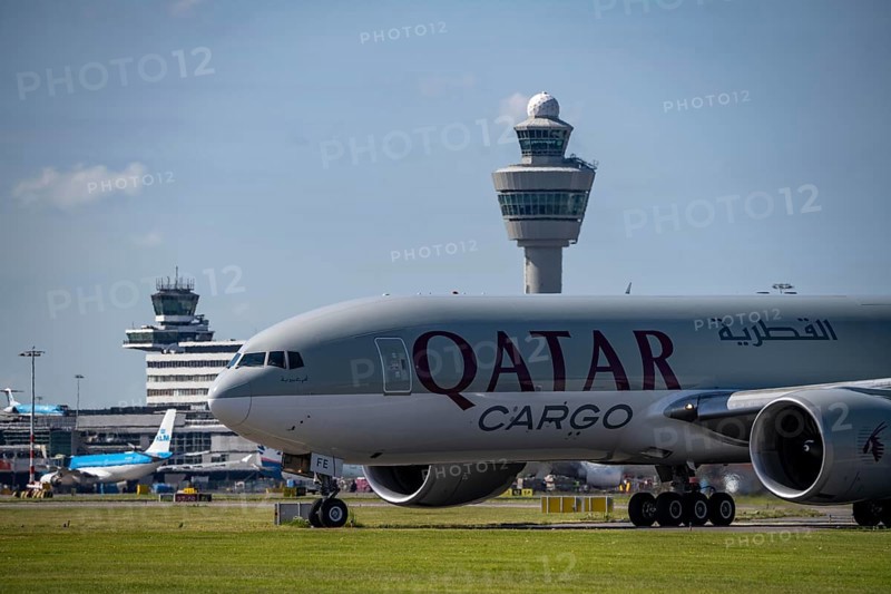 Aircraft at Amsterdam Schiphol Airport, on the taxiway for take-off on the Aalsmeerbaan, 18L/36R, Qatar Cargo aircraft, Boeing 777-200, air traffic control tower, terminal, Netherlands