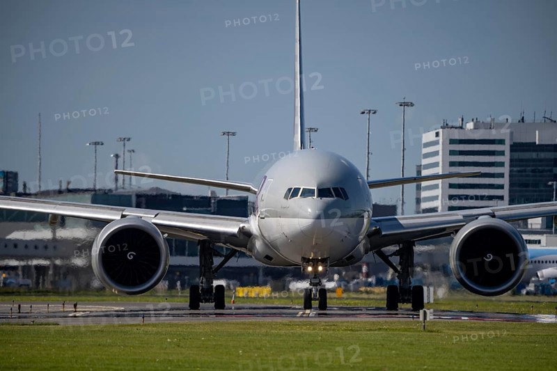 Aircraft at Amsterdam Schiphol Airport, on the taxiway for take-off on the Aalsmeerbaan, 18L/36R, Qatar Cargo aircraft, Boeing 777-200, air traffic control tower, terminal, Netherlands
